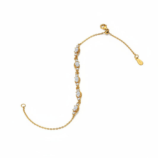 Gold bracelet with diamond-like stones on a white background