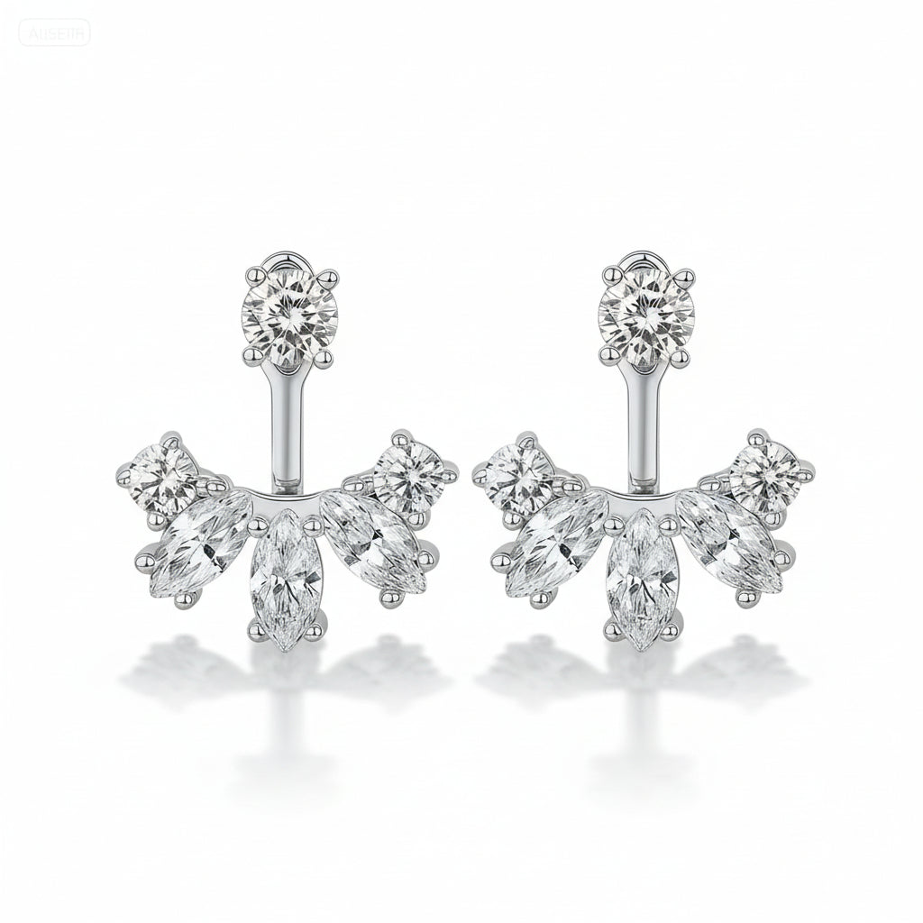 Silver earrings with clear gemstones on a green satin background