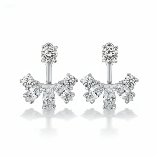 Silver earrings with clear gemstones on a green satin background