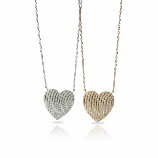 Two heart-shaped pendants on chains against a white background