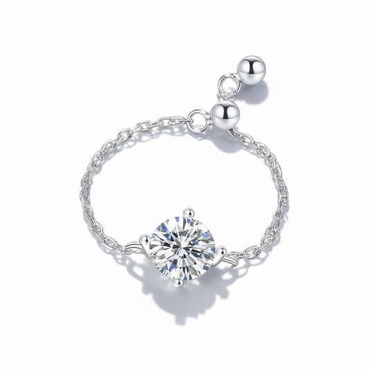 Silver bracelet with a heart-shaped gemstone on a soft green background with pink petals.