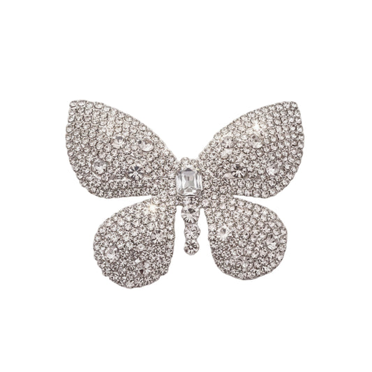 Butterfly-shaped brooch with rhinestones on a white background